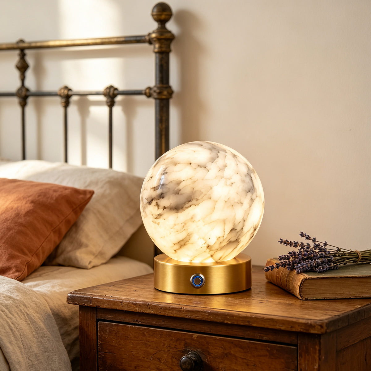 Glowing alabaster globe table lamp beside a bed