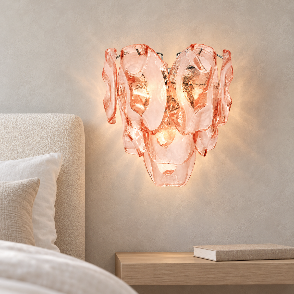 Lucent Petal pink glass wall sconce beside a cream upholstered bed