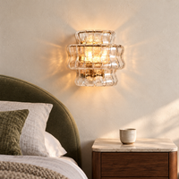 Ondelle Clear glass wall sconce in a warm bedroom
